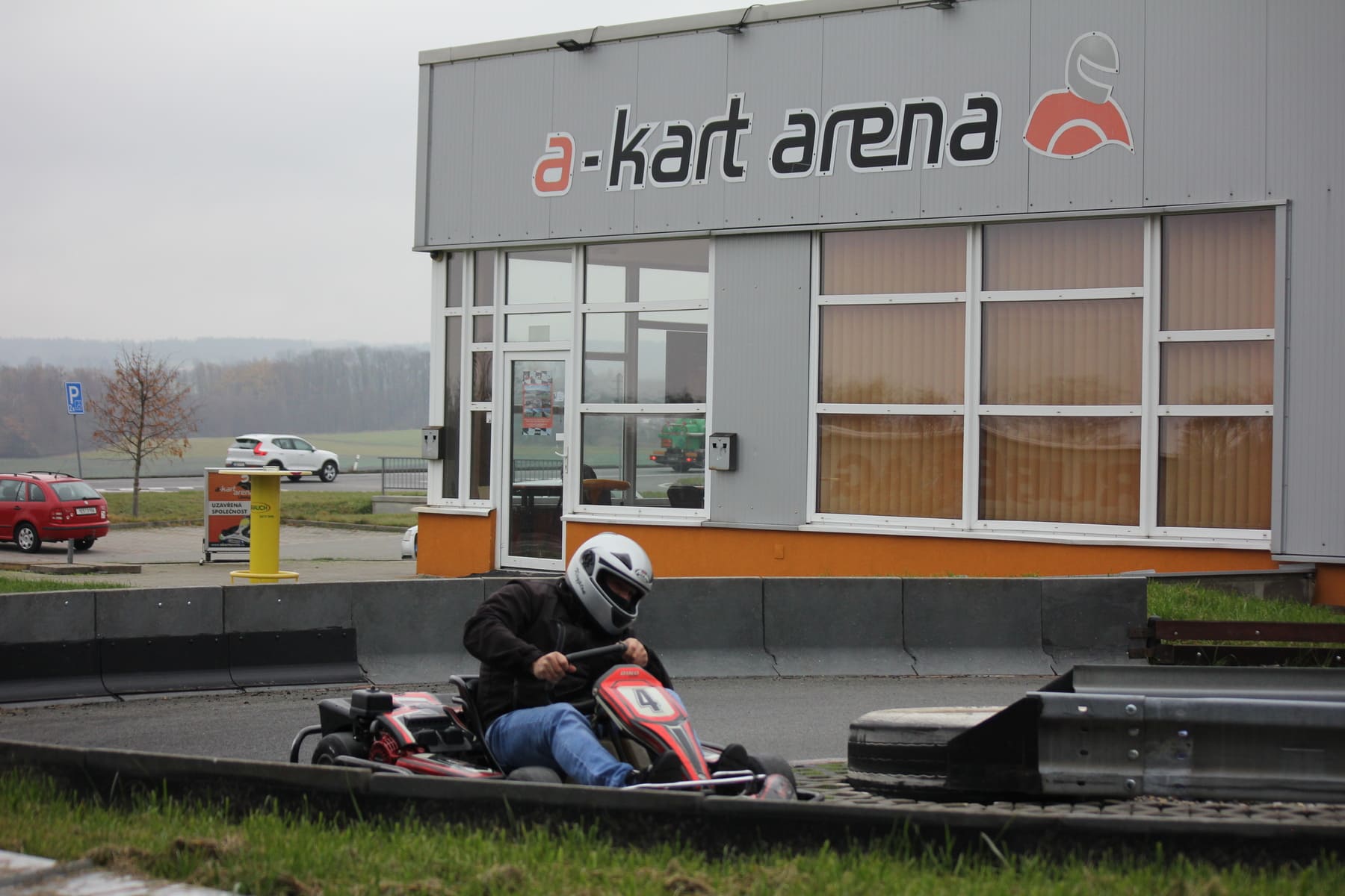Exteriér haly A-Kart Arena s jezdcem na venkovní dráze