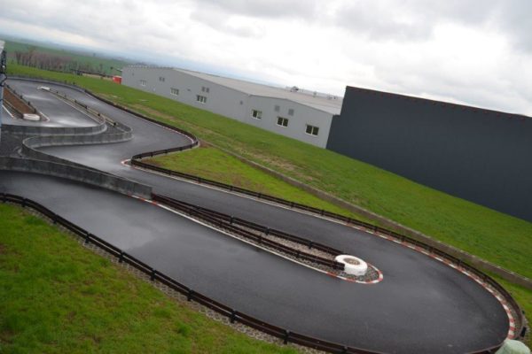 Venkovní asfaltový okruh klikatící se kolem haly A-Kart Arena