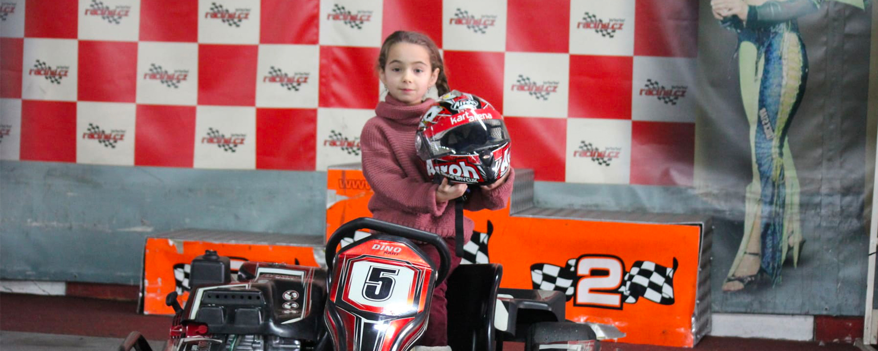Dítě s helmou A-Kart Arena u motokáry číslo 5